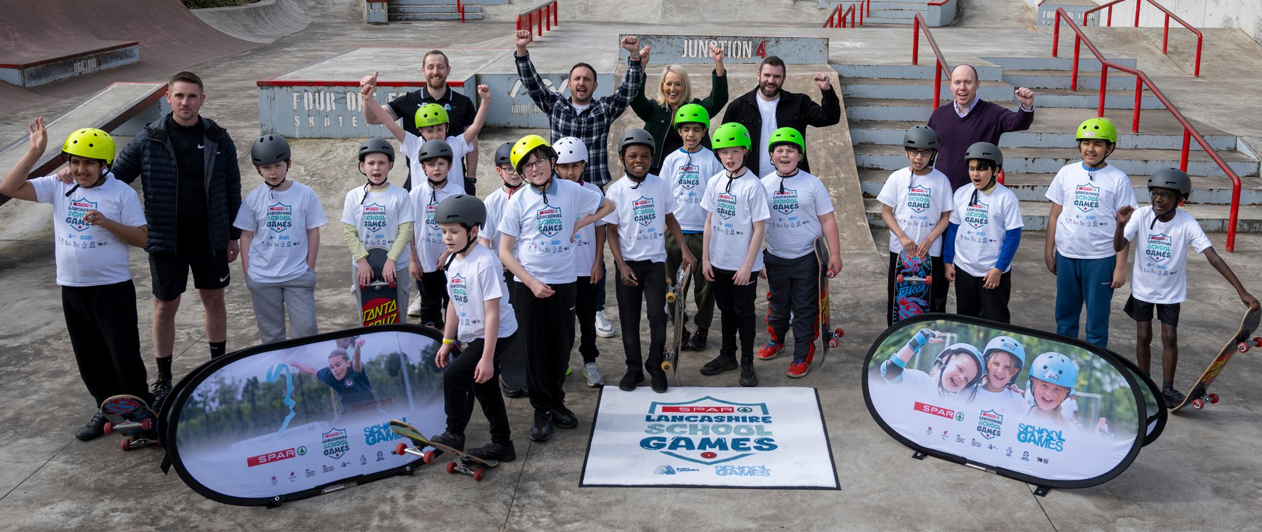 Adults and kids posing for a photo at a skate park