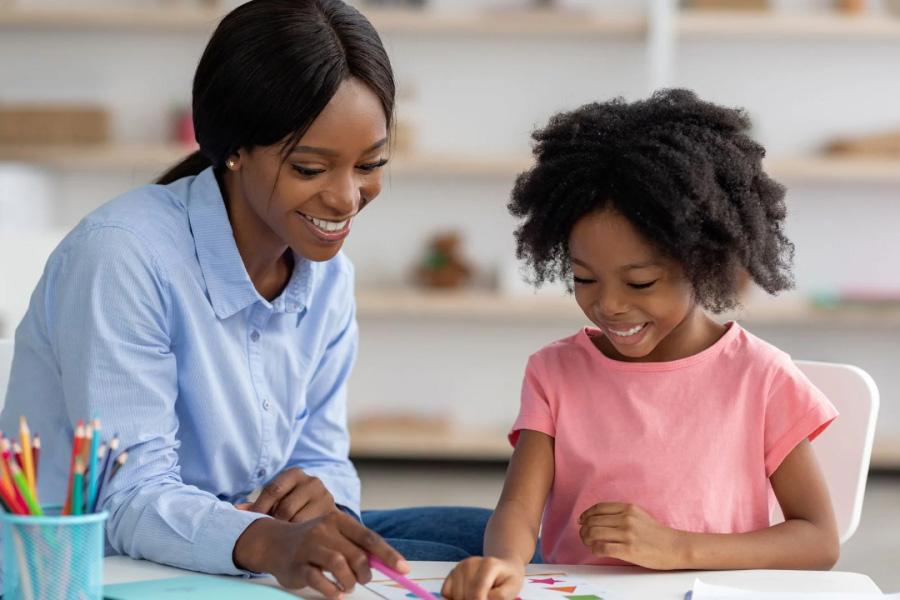 A woman helping a young girl with school work