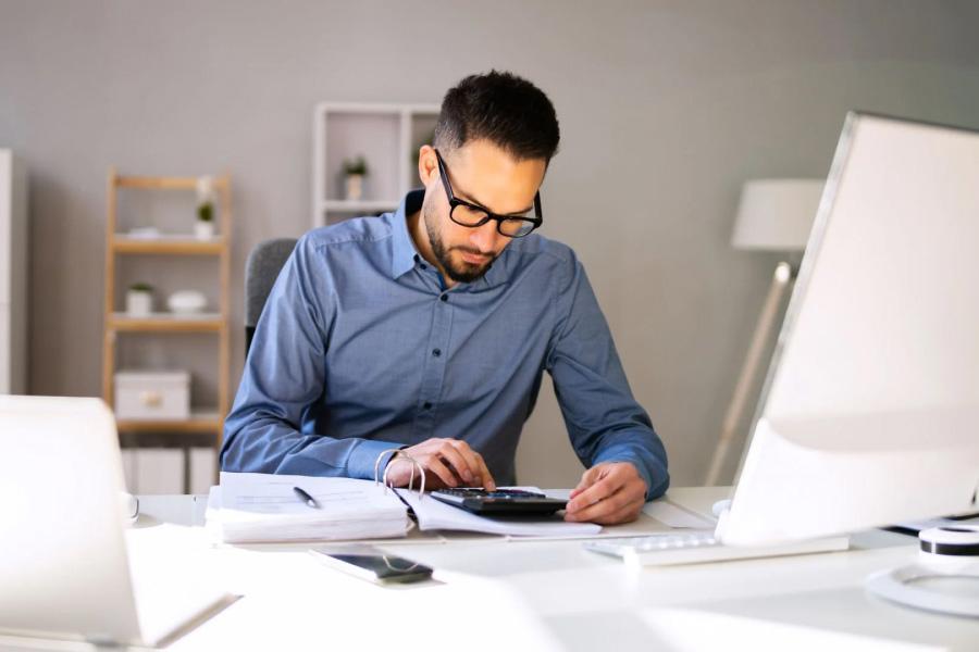 A man using a calculator at a desk