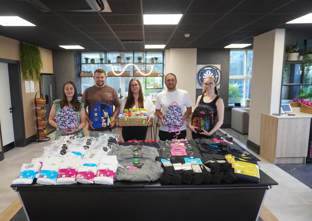 Five people with a table of donations
