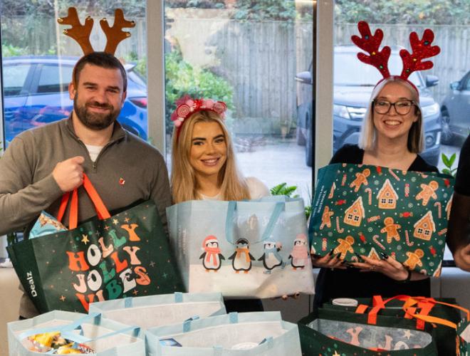 Three people with Christmas themed bags