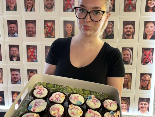 A woman with a tray of cupcakes